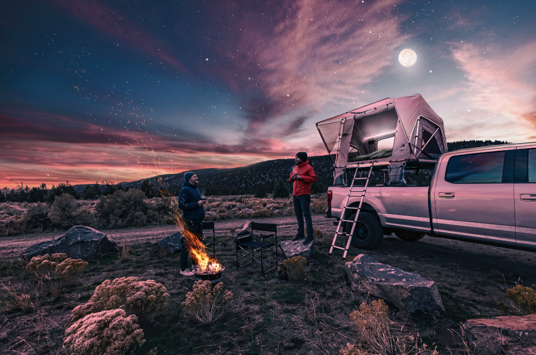 Campers at twilight campfire with Adventure series gas strut rooftop tent